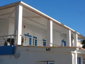 a balcony of a white building with blue accents at Villa Giorgos in Kefalos