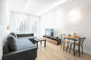 una sala de estar con un sofá y una mesa en MYE Apartments - Ilumino, en Łódź