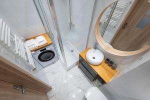 vistas a un baño con lavabo y espejo en MYE Apartments - Ilumino, en Łódź 8 fotos más