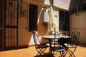 a room with a table and chairs and an umbrella at Casa Colapesce in Messina