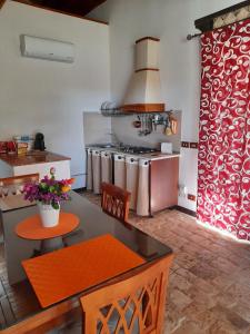 a kitchen with a stove and a table and chairs at Casale Oasi in Pozzallo +6 photos