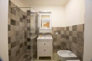 Un baño con lavabo, inodoro y espejo. en Casa Claudia, en Ravello