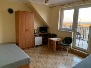 um quarto com uma cama, uma secretária e uma varanda em Pokoje Gościnne ADRIAN em Krynica Morska