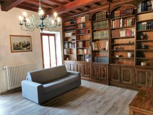 ein Wohnzimmer mit einem Stuhl und Bücherregalen in der Unterkunft Casa Remo - dolce soggiorno nella Piazza di Greve in Greve in Chianti