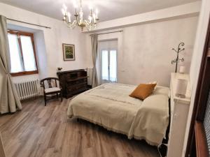 a bedroom with a bed and a chandelier at Casa Remo - dolce soggiorno nella Piazza di Greve in Greve in Chianti