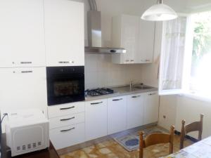 a kitchen with white cabinets and a stove top oven at I Limoni di Matteo in Biassa