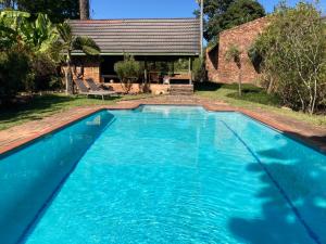 a large blue swimming pool in front of a house at Halleria Self Catering in White River