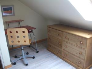 a desk and a chair next to a dresser in a room at Logement ST GILDAS in Pommerit-Jaudy