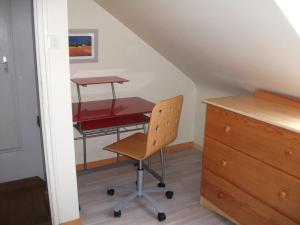 a desk and a chair in a room at Logement ST GILDAS in Pommerit-Jaudy