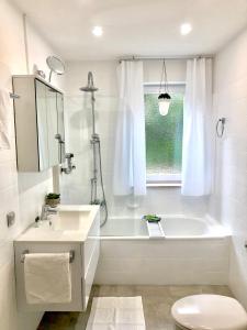 a bathroom with a tub and a sink and a toilet at Auszeit in Überlingen