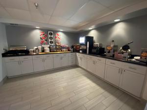 une cuisine avec des placards blancs et un comptoir dans l'établissement Ramada by Wyndham Luling, à Luling