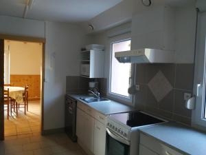 een keuken met een wastafel en een fornuis top oven bij Appartement 4 personnes tout équipé VOSGES. in Rochesson