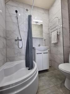 a bathroom with a tub and a toilet and a sink at Danyla Galytskogo apartment Центр міста, старе місто 5хв in Kamianets-Podilskyi +15 photos