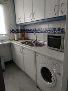 uma cozinha com um lavatório e uma máquina de lavar roupa em Apartamento vacacional máximo 4 personas em Novo Sancti Petri