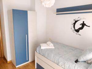 Un dormitorio con una cama y una tabla de surf en la pared. en APARTAMENTO KENITRA, en Avilés