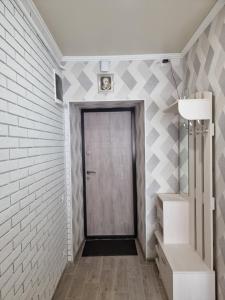 a hallway with a door and a brick wall at Danyla Galytskogo apartment Центр міста, старе місто 5хв in Kamianets-Podilskyi +15 photos