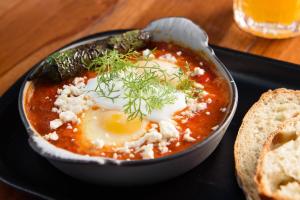 a bowl of soup with an egg and some bread at Diez Diez Collection in Mérida