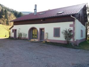 une maison blanche avec un toit marron et une allée. dans l'établissement Appartement 4 personnes tout équipé VOSGES., à Rochesson