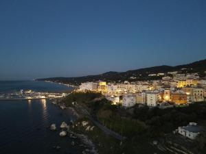 a city at night with the water and buildings at La casa del corso in Rodi Garganico