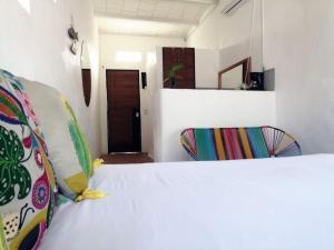 a white bed with two chairs in a room at Estudio sobre calle principal con vista a la plaza in Sayulita