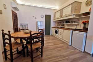 Il comprend une cuisine avec une table en bois et du parquet. dans l'établissement Casa Alda - magica vista sulla Piazza di Greve, à Greve in Chianti