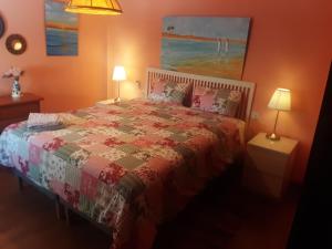 1 dormitorio con 1 cama con edredón y 2 lámparas en Apartamento Naturaleza Virgen, en Matalascañas