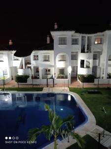 a villa with a swimming pool at night at Apartamento vacacional máximo 4 personas in Novo Sancti Petri