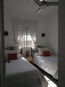 een slaapkamer met 2 bedden en een raam bij Apartamento vacacional máximo 4 personas in Novo Sancti Petri