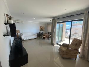 a living room with a couch and chairs and a large window at Casa da Praia 901 in Portimão