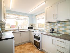 a kitchen with white cabinets and a sink at 75 Mansfield Road in Ault Hucknall