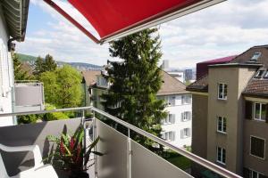 uma varanda com vista para alguns edifícios em Turicum Apartment mit Balkon und Parkplatz em Zürich