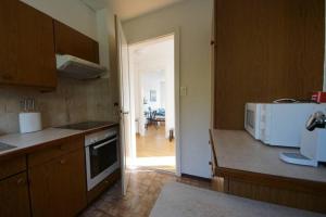 eine Küche mit einer Mikrowelle und eine Tür zu einem Esszimmer in der Unterkunft Turicum Apartment mit Balkon und Parkplatz in Zürich