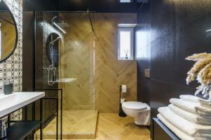 La salle de bains est pourvue d'une douche et de toilettes. dans l'établissement Loftowy apartament w sercu Śląska, à Ruda Śląska