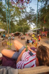 Eine Frau, die auf einem Handtuch am Strand liegt. in der Unterkunft Progress Outdoor Surf Hostel in Moliets-et-Maa