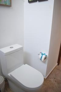 a white toilet sitting next to a white wall at Amaka Calma Riviera Tulum in Tulum