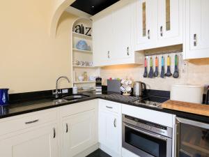 ダートマスにある3 Dartviewの白いキャビネットと黒いカウンタートップを備えたキッチン +11枚の写真