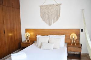 a bed with a white bedspread and pillows at Amaka Calma Riviera Tulum in Tulum