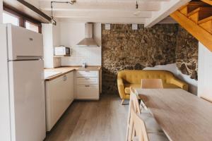 a kitchen and dining room with a table and a couch at EL CORRAL DEL CARTERU - Casa Rosales in Infiesto