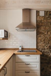 a kitchen with white cabinets and a stove top oven at EL CORRAL DEL CARTERU - Casa Rosales in Infiesto