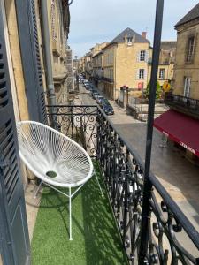 a white chair sitting on the balcony of a building at Le cosy in Sarlat-la-Canéda