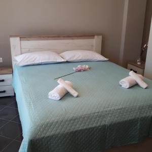 een bed met twee paar slippers en twee poppen erop bij Sp+P apartment in Alepou