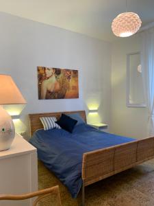 una camera da letto con un letto con lenzuola blu e un dipinto di Da u Franchin a Carloforte