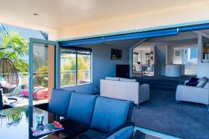 d'un salon avec des murs et des fenêtres bleus. dans l'établissement Soul Retreat - Cable Bay Holiday Home, à Cable Bay