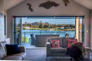 a living room with a couch and a view of the water at Soul Retreat - Cable Bay Holiday Home in Cable Bay