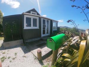 a green tiny house with a green mailbox at Rock Retreat B&B farmstay in Waitomo Caves