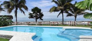 a swimming pool with a view of the ocean at Caramba Hospedaje in Tonsupa