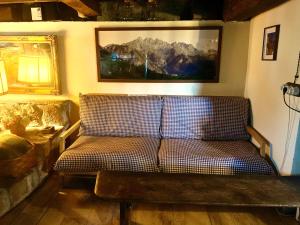 a couch in a room with a picture on the wall at La Cabaña del Beyu Pen in Amieva