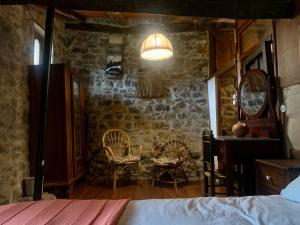 a bedroom with a bed and two chairs in a room at La Cabaña del Beyu Pen in Amieva
