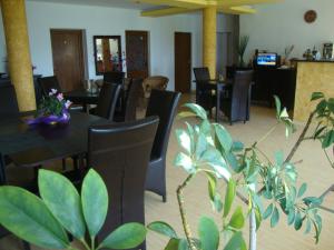 a dining room with tables and chairs and plants at Casa Lacul Sarat in Techirghiol