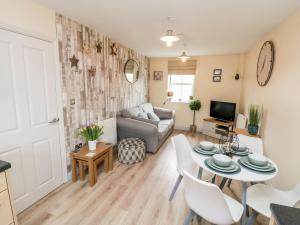 a living room with a table and a couch at The Starfish Shack in Filey